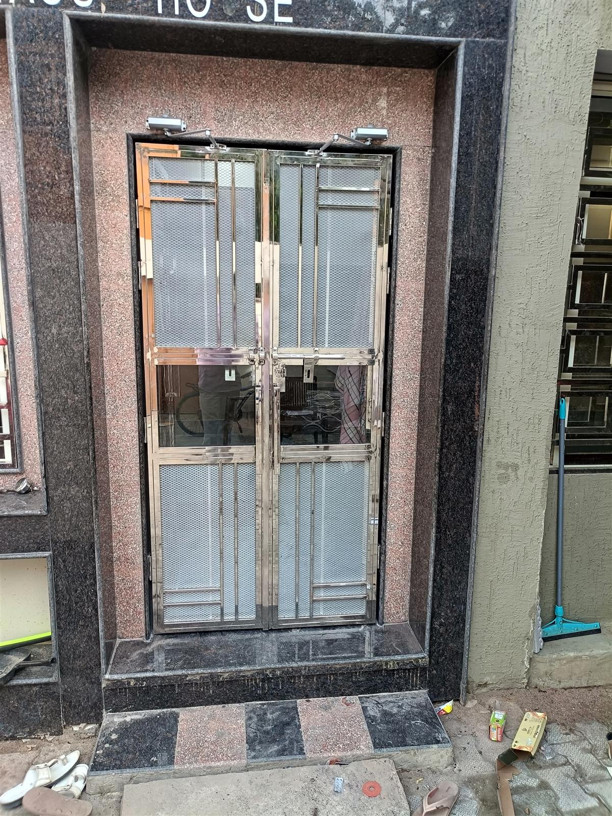 Polished steel doors at a granite entrance